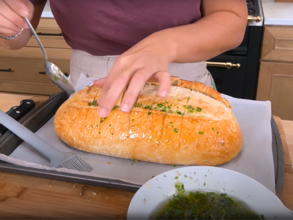 Brush the garlic butter mixture generously over the dough, making sure to get it into all the cuts.