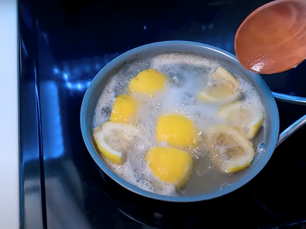 Place the lemon slices into the pan, ensuring they cover the burnt areas. 2