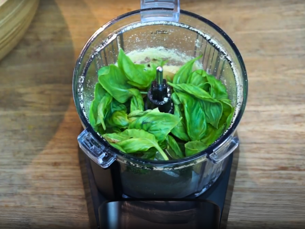 Place the basil leaves, Parmesan cheese, pine nuts, and garlic cloves in a food processor 2