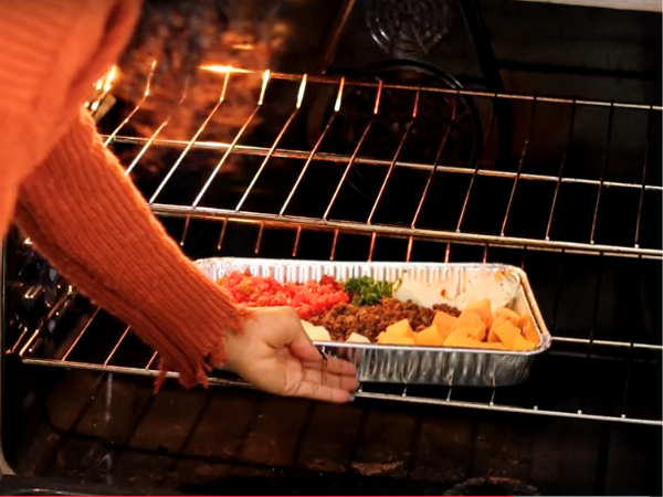 Place the baking tray with the meat and cheese mixture in the preheated oven.