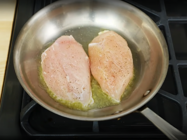 Place the seasoned chicken breasts in the skillet.